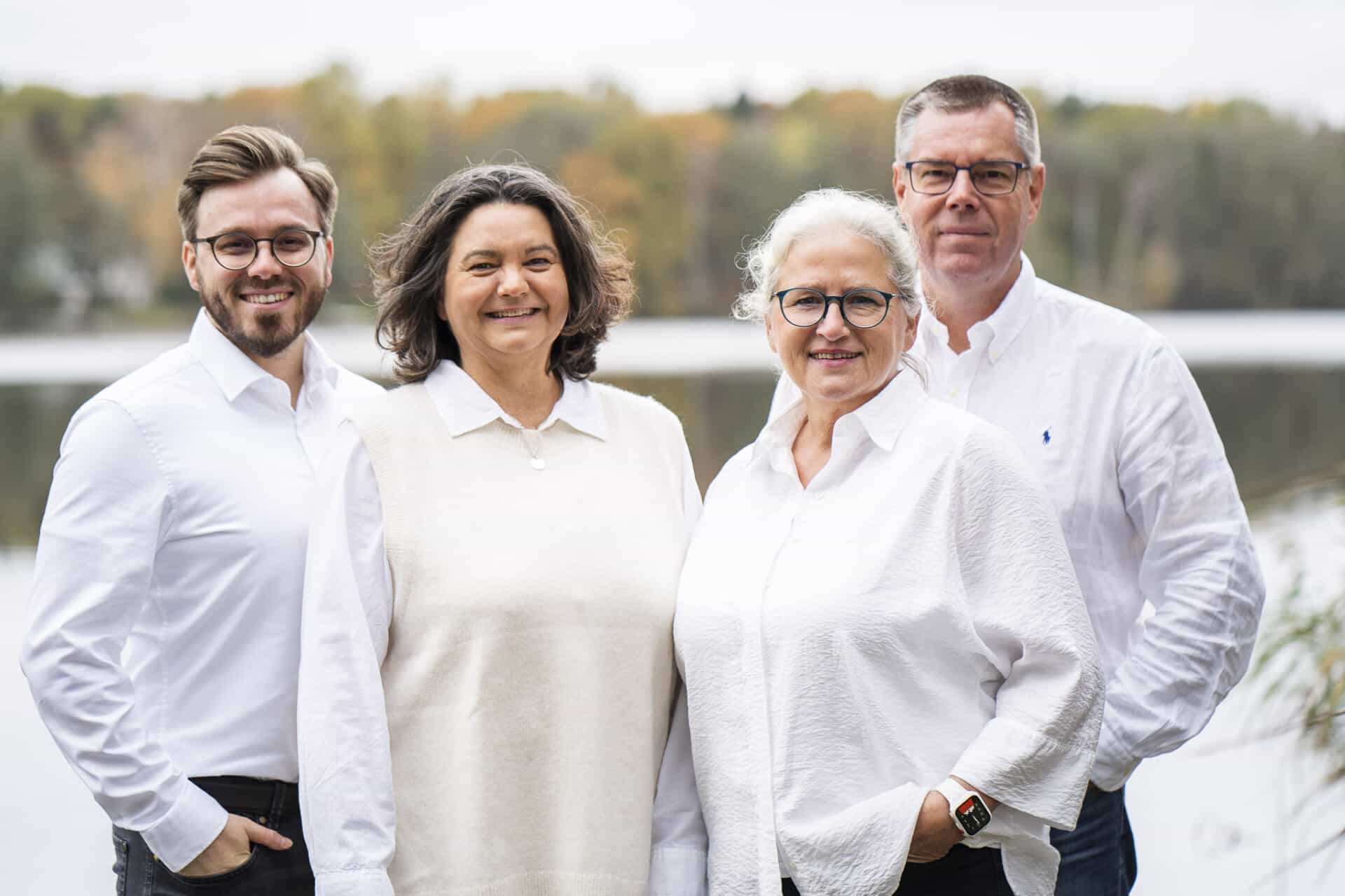 Team der IMMO.BEING Hausverwaltung, zwei Frauen und zwei Männer mit weißer Kleidung stehen auf einem Steg vor dem Dümmer See.